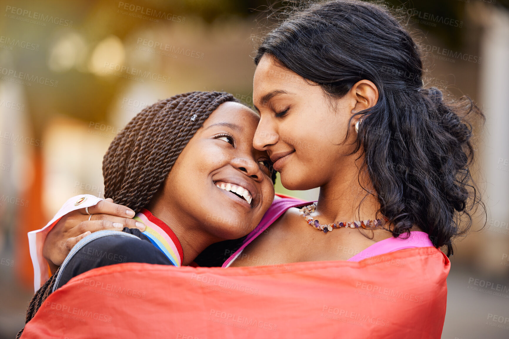 Buy stock photo Love, hug and happy lesbian couple at a freedom, equality or LGBTQ festival, event or parade. Happiness, smile and gen z interracial gay women embracing, hugging and bonding together in the city.