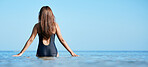 Beach horizon in summer, young woman in water on vacation in Mauritius and swimming in the blue ocean. Calm female tourist in sea, freedom of travel lifestyle or relaxing on coastal destination