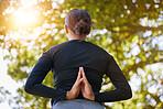 Yoga, prayer hands and back of woman at park for health, wellness and flexibility. Zen chakra, pilates and female meditating, stretching and training outdoors alone in nature for workout or exercise.