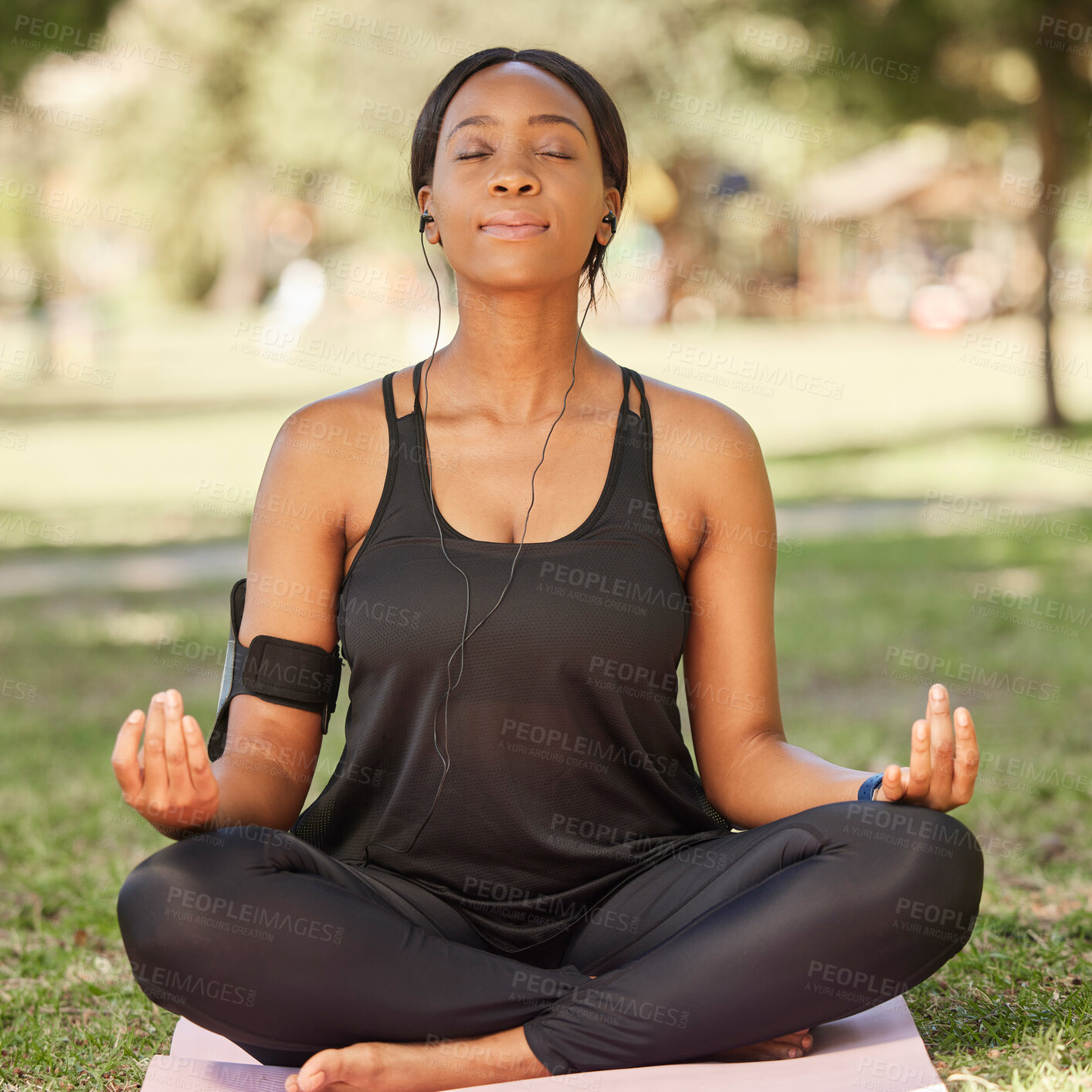 Buy stock photo Yoga, black woman meditation in park with lotus pose, earphone for mindfulness podcast and zen outdoor in nature. Peace, spiritual energy and balance self care and music with fitness and wellness