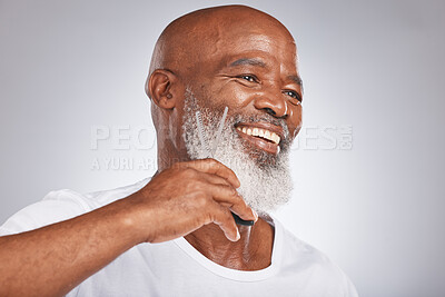 Buy stock photo Beard, beauty and shave with a senior black man grooming his facial hair in studio on a gray background while cutting. Happy, skin and face with a mature male using scissors to cut for shaving
