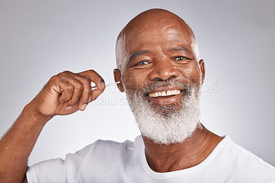 Buy stock photo Portrait, cotton and a black man cleaning his ear in studio on a gray background for hygiene or grooming. Earbud, face and smile with a happy senior male in the bathroom to clean out earwax