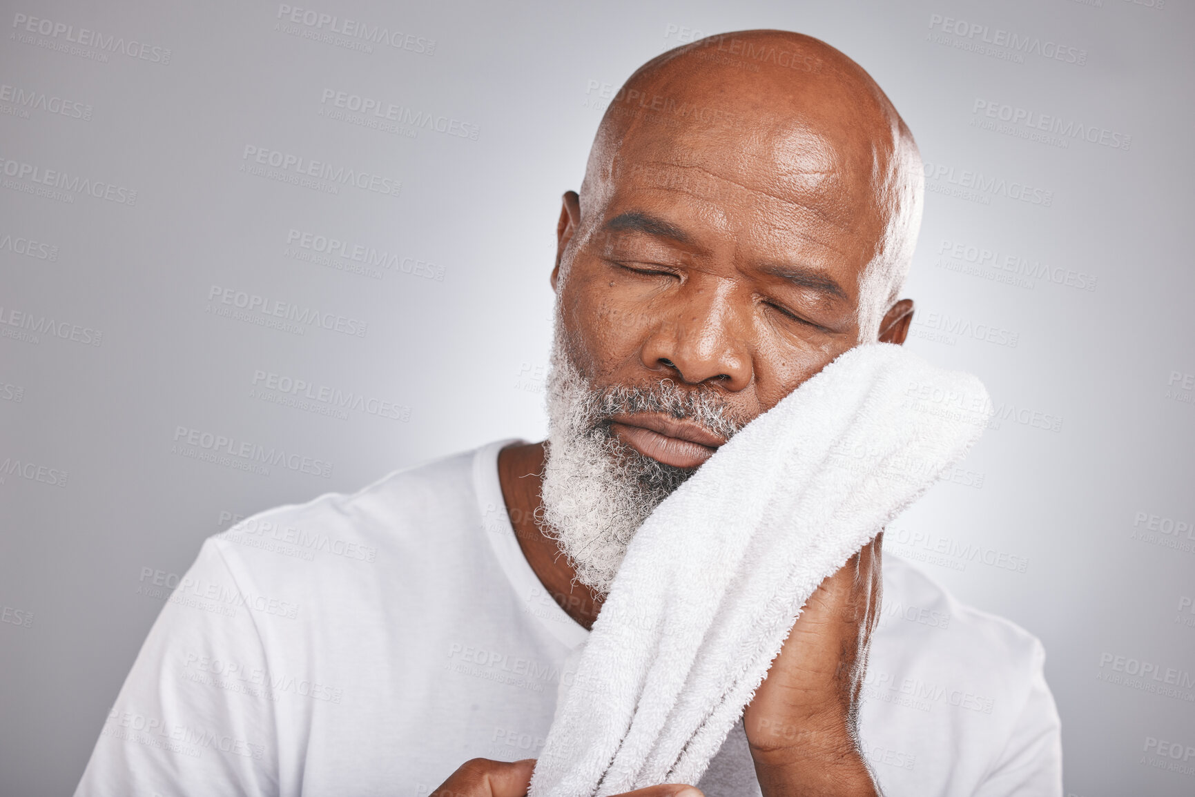 Buy stock photo Skincare, cleaning or old man with a face towel in studio with marketing or mock up space for beauty. Wellness, glowing skin or healthy senior black man grooming with facial cosmetics or product