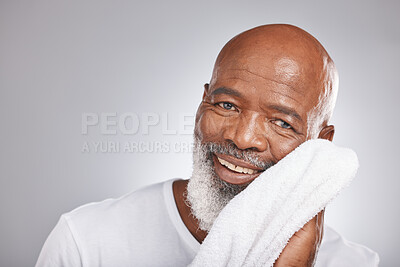 Buy stock photo Skincare, portrait or old man with a face towel in studio with marketing or mock up space for beauty. Happy smile, glowing skin or healthy senior black man grooming with facial cosmetics or product