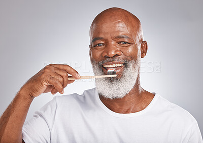 Buy stock photo Brushing teeth, studio portrait and black man with toothbrush for mature dental wellness, healthy lifestyle or cleaning aesthetic in Nigeria. Happy face, male model and oral mouth care of fresh smile