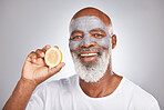 Skincare, lemon or happy old man with face mask marketing or advertising a healthy diet or fruit. Studio background, cosmetics or senior black man with a happy smile applying beauty product cream
