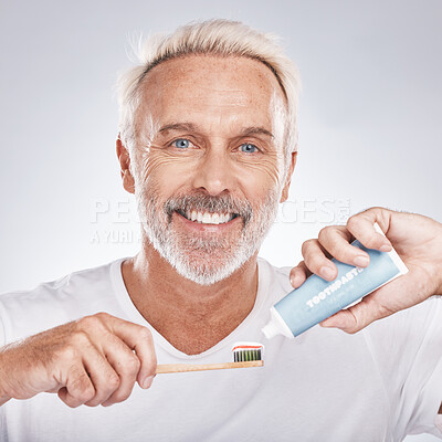 Buy stock photo Toothbrush, face and senior man with toothpaste in studio on a gray background. Portrait, cleaning and elderly male model holding product for brushing teeth, dental wellness and healthy gum hygiene.