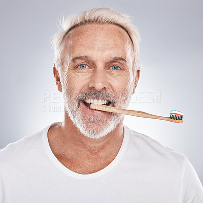 Buy stock photo Dental care, hygiene and grooming man brushing teeth for healthy smile, mouth wellness and healthcare on a studio background. Oral care, toothbrush and face portrait of a senior model cleaning teeth