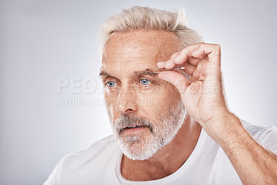 Buy stock photo Man face, hand or tweezing eyebrow in grooming on gray studio background, facial self care or wellness beauty aesthetic. Headshot, mature model or hair removal tweezers in cleaning growth maintenance