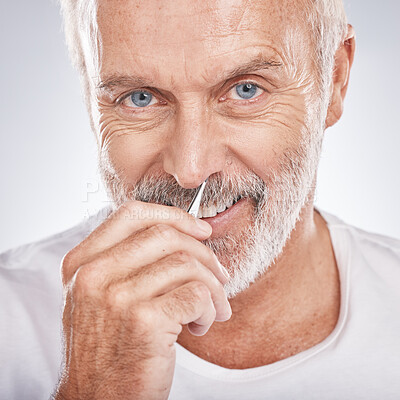 Buy stock photo Portrait, tweezers and nose with a senior man in studio on a gray background for grooming or personal hygiene. Face, hand and equioment with a mature male tweezing to remove nasal hair in a bathroom