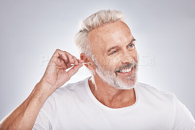 Buy stock photo Elderly man, ear cleaning with cotton swab for hygiene, grooming and clean body with cosmetic care against studio background. Beauty, health and wellness, senior male and happy with natural cosmetics