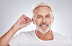 Senior man, cotton bud and ear cleaning happy portrait in white studio background for grooming hygiene, healthy wellness and wax removal. Elderly model, cosmetics ears cleaner and body care happiness