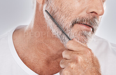 Buy stock photo Face, senior man and beard comb in studio isolated on a gray background. Skincare, facial hair care and elderly retired male model with product, tool or accessory for grooming, beauty and aesthetics.