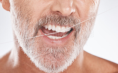 Buy stock photo Floss, dental and face of senior man in studio isolated on a gray background. Cleaning, hygiene and elderly male model with product flossing teeth for oral wellness, tooth care and healthy mouth.