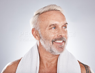 Buy stock photo Senior man, beauty and skincare while grooming, happy and clean after a shower with a towel on a gray background. Face of a old male model with a smile for cosmetics, dermatology and healthy skin