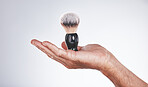 Makeup, cosmetics and hand of man with brush in studio isolated on a gray background mockup. Skincare, aesthetics and male model holding product, accessory or tool for grooming, beauty and wellness.