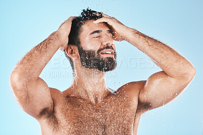 Buy stock photo Water, shower and hair with a man cleaning using shampoo in studio on a blue background for beauty or hygiene. Washing, clean and keratin with a handsome male wet in a bathroom for natural haircare