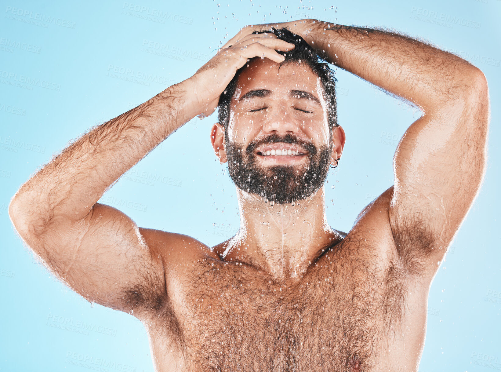 Buy stock photo Cleaning, hair and keratin treatment with a man model using shampoo in studio on a blue background for hygiene. Water, hydration and natural with a handsome male washing in the shower for haircare
