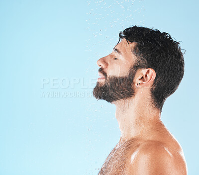Buy stock photo Water, cleaning and face with man and beauty, shower for hygiene and grooming with skincare against blue studio background. Clean, model profile with water drops and natural cosmetic treatment mockup