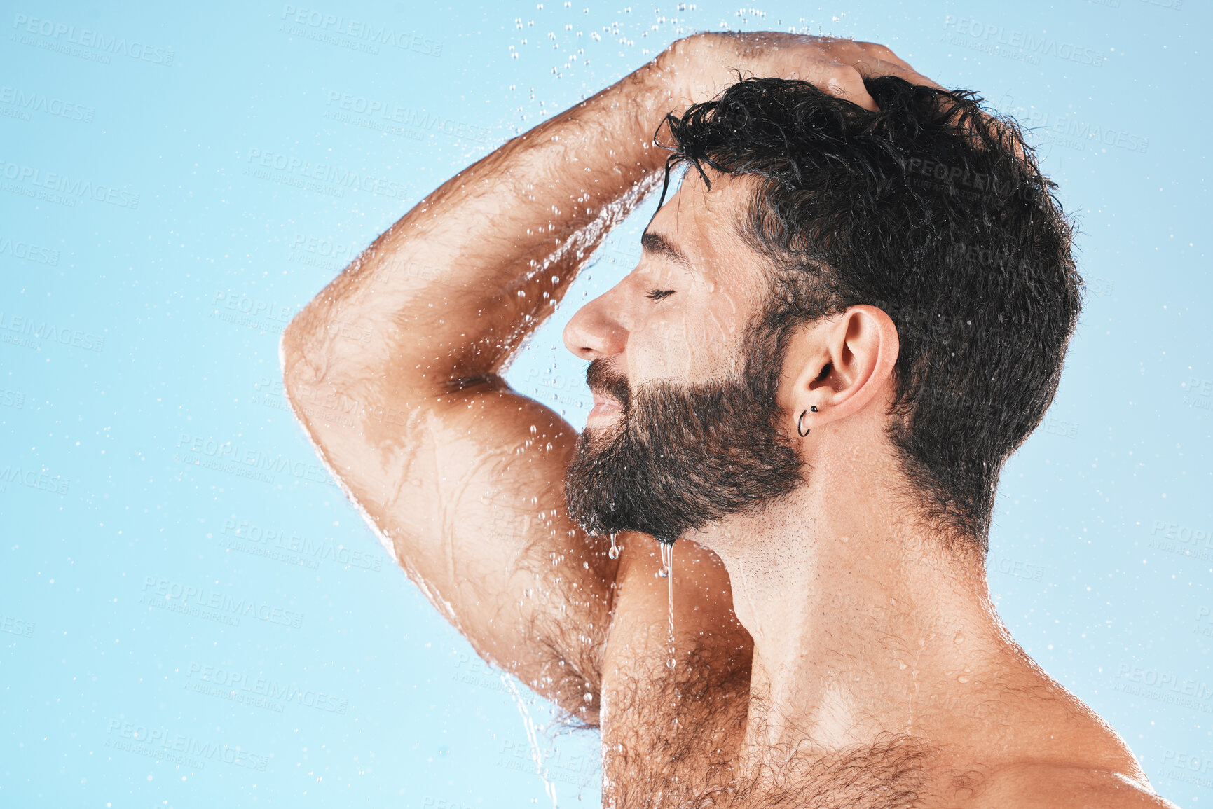 Buy stock photo Head, hair and hygiene with a model man using shampoo for cleaning in studio on a blue background. Water, wet and wellness with a handsome male washing for haircare, hydration or keratin treatment
