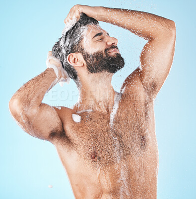 Buy stock photo Haircare, keratin and cleaning with a man in studio on a blue background to take a shower for hygiene. Water, skin and relax with a male washing his hair with shampoo treatment in the bathroom