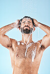 Soap, water or man in shower cleaning skin, washing face or body in healthy morning grooming routine in studio. Blue background, relaxing or male model with self care, self love or foam for hair care