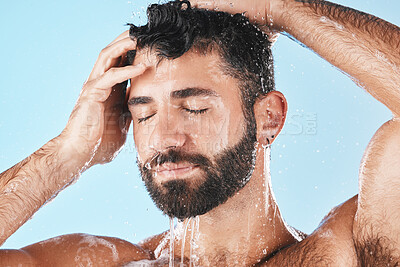 Buy stock photo Face, hair care shower and water splash of man in studio isolated on a blue background. Dermatology, water drops and male model washing, cleaning and bathing for healthy skin, skincare and hygiene.