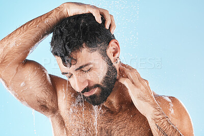 Buy stock photo Hair care, face and water splash of man in shower in studio isolated on a blue background. Water drops, dermatology and male model washing, cleaning or bathing for skincare, wellness and hygiene.