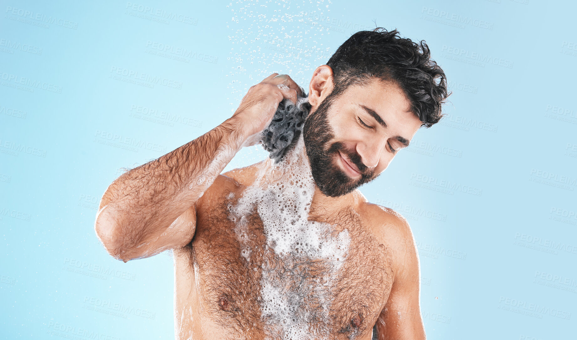 Buy stock photo Shower, happy and man cleaning body with soap for health, fresh wellness and morning routine on a blue studio background. Skincare, water and model washing to clean skin for hygiene treatment
