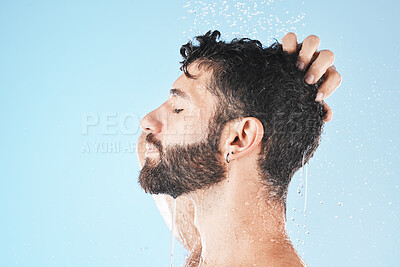 Buy stock photo Water splash, face and man in shower for skincare in studio on a blue background mock up. Dermatology, water drops and profile of male model cleaning, bathing or washing for healthy skin and hygiene.