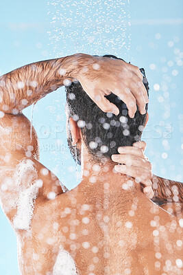 Buy stock photo Beauty, cleaning hair and man in shower to wash with shampoo, conditioner and hair products. Hygiene, grooming and back of male washing body for self care, wellness and skincare on blue background