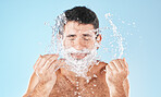 Man, shave and face with water splash in studio for wellness, health and self care by blue background. Healthy model, bathroom and smile with splash for facial, skin product and cosmetics by backdrop