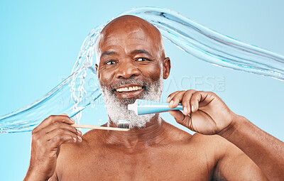 Water splash, oral hygiene and portrait of a man in a studio for mouth health and wellness. Toothpaste, toothbrush and elderly African guy brushing his teeth for fresh dental care by blue background.