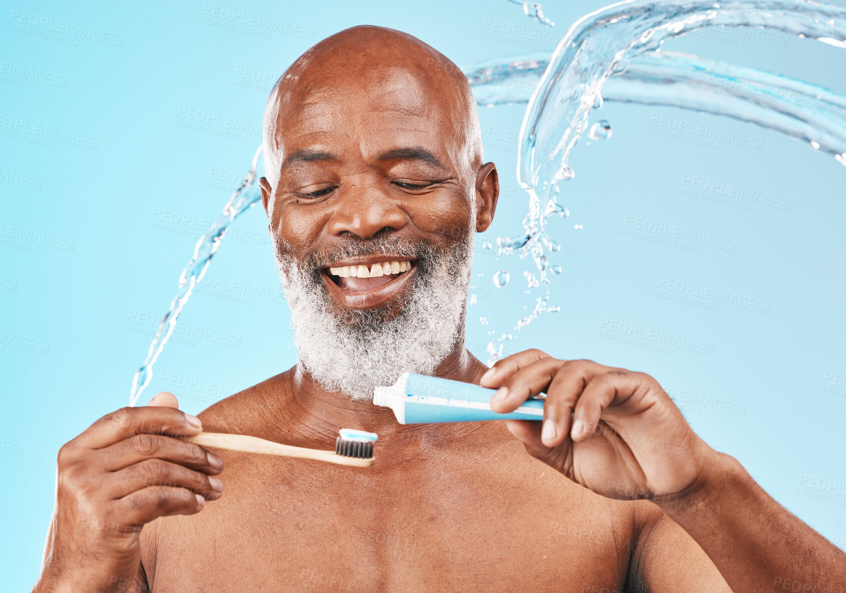 Buy stock photo Water, splash and man with dental care in a studio for mouth health and wellness. Toothpaste, toothbrush and elderly African guy brushing his teeth for fresh oral hygiene isolated by blue background.