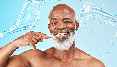 Black man, dental hygiene and toothbrush with water, wellness and hygiene against blue studio background. Oral health, African American male and mature guy with smile, toothpaste and clean mouth.