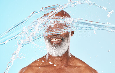 Buy stock photo Happy black man, face and water splash in studio for cleaning, self care and headshot cosmetics on blue background. Shower, wellness and male beauty with water drops, healthy skincare and facial body