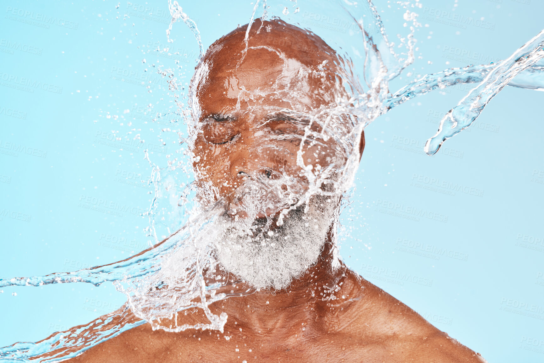 Buy stock photo Elderly black man, water splash and face in studio for wellness, clean or facial health by backdrop. Man, model face and water for skincare, healthy self care or cosmetic beauty by blue background