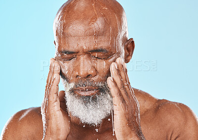 Buy stock photo Black man, face and water drip in studio for cleaning cosmetics, wellness and healthy skincare on blue background. Male model, water splash and wet shower for facial beauty, aesthetic and self care