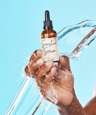 Buy stock photo Serum, skincare and hand of a man with a water splash for an anti aging product, beauty and hair growth secret on a blue background in studio. Cosmetic, marketing and model with an oil for acne