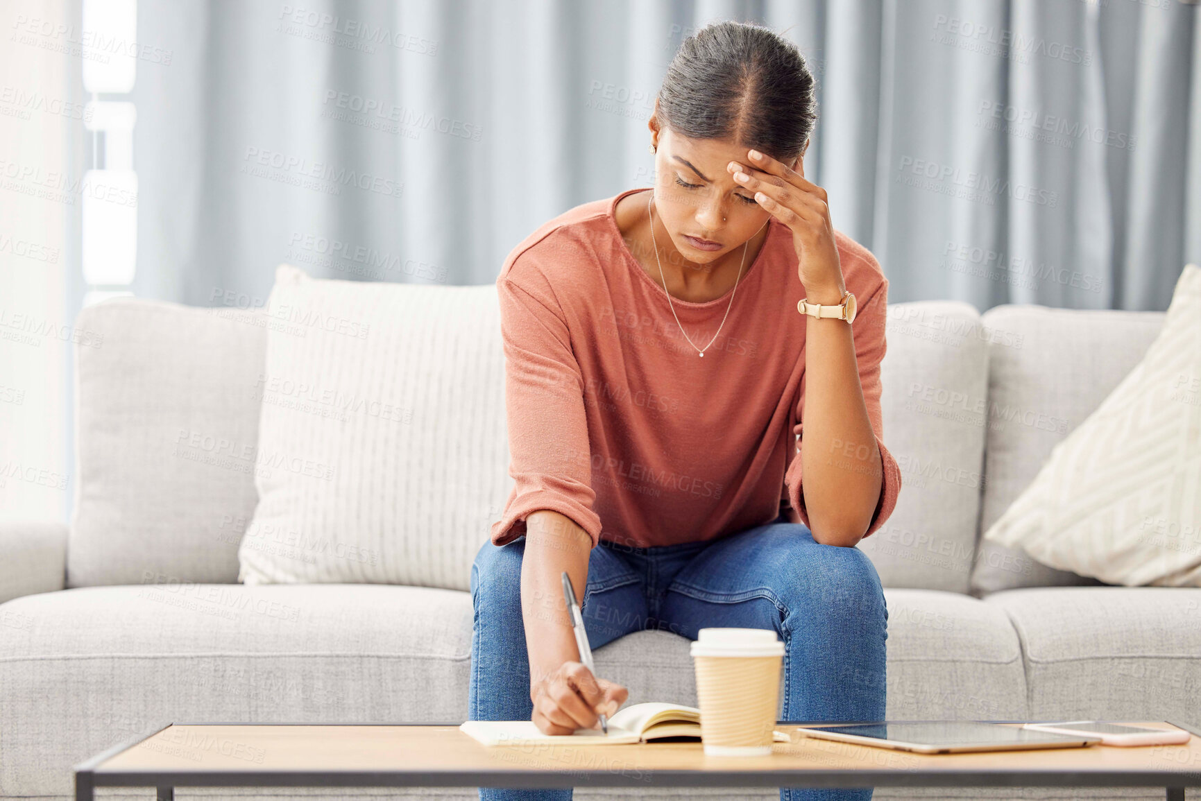 Buy stock photo Stress, woman writing and sofa with headache, mental health and debt pressure. Latino female, girl and make notes in book, journal and budget with financial crisis, depression and anxiety in lounge