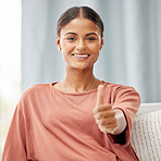 Thumbs up, happy and portrait of Indian woman on sofa in living room relaxing on weekend, free time and holiday. Home, smile and female on couch with hand gesture for yes, thank you and support