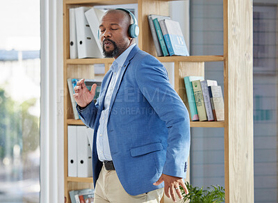 Buy stock photo Music, dance and headphones with a business black man manager dancing in his office at work. Wellness, radio and freedom with a senior male worker listening or streaming audio while working