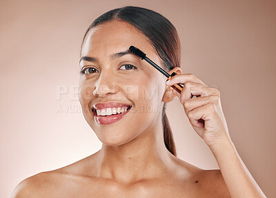 Buy stock photo Beauty portrait and eyebrow brush of woman for grooming routine with natural skincare and smile. Young cosmetic girl model with healthy skin brushing facial hair on beige studio background.


