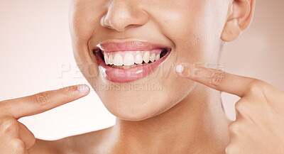 Buy stock photo Smile, mouth and woman pointing to teeth on studio background for wellness, aesthetic beauty and healthy cosmetics. Closeup model showing clean dental skin, fresh breath and teeth whitening results