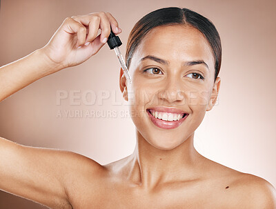 Buy stock photo Skincare, beauty and woman with a face serum for a natural, wellness and cosmetic face routine in a studio. Health, glow and female model from Brazil with a facial oil isolated by a brown background.