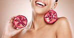 Beauty, pomegranate and skincare with woman, natural product for healthy skin, wellness and cosmetic care. Happy glow, shine with vegan cosmetics and fruit for facial treatment with studio background