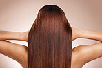 Hair, beauty and back of woman in studio for hair care, hair products and cosmetics on beige background. Salon, balayage and girl touch healthy, shine and long hair for hair salon, treatment and glow