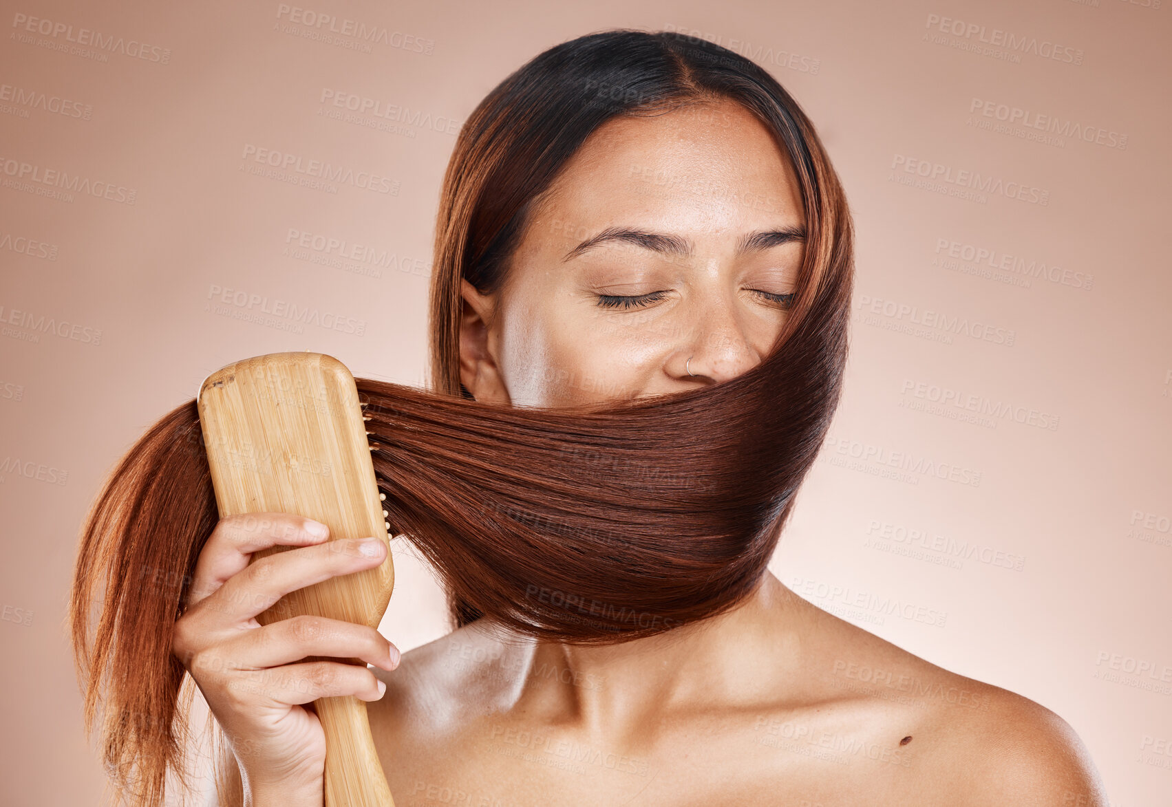 Buy stock photo Hair care, beauty and brush with a woman brushing after salon, hairdresser or shampoo treatment in studio. Face of aesthetic female model grooming clean hair in studio for health and wellness mockup