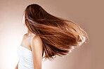 Beauty, skincare and hair care of woman in studio on a brown background. Hairstyle, cosmetics and aesthetics of young female model with balayage after salon treatment for healthy growth and texture.