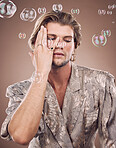 Beauty, fashion and man with bubbles in studio on brown background for cosmetics, style and modern outfit. Creative art, luxury design and male fashion model with soap bubbles, jewellery and makeup